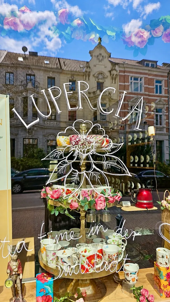 Lupercia’s shop window with a floral logo and reflections of houses in Bonn’s Südstadt
