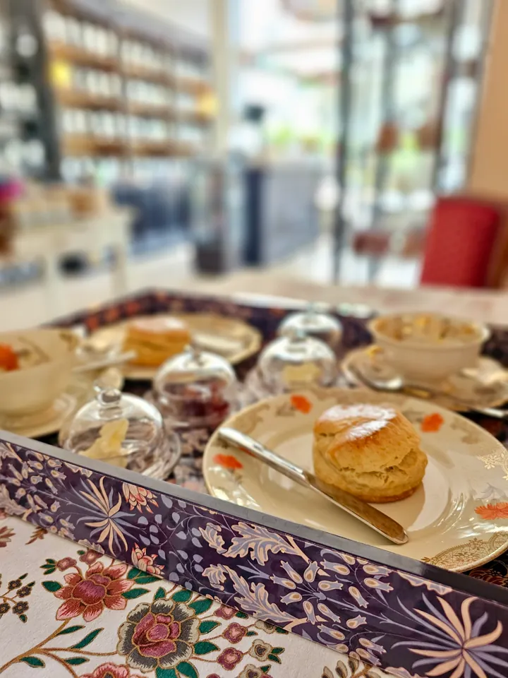 Scones, jam and cream on a tray set with floral porcelain