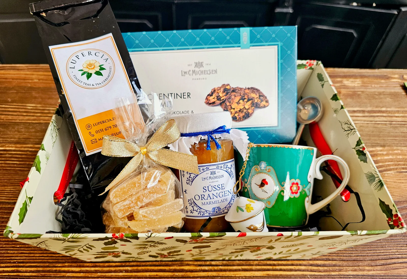 Una caja de regalo con té Lupercia, una taza de porcelana turquesa, florentinas, jengibre y mermelada de naranja