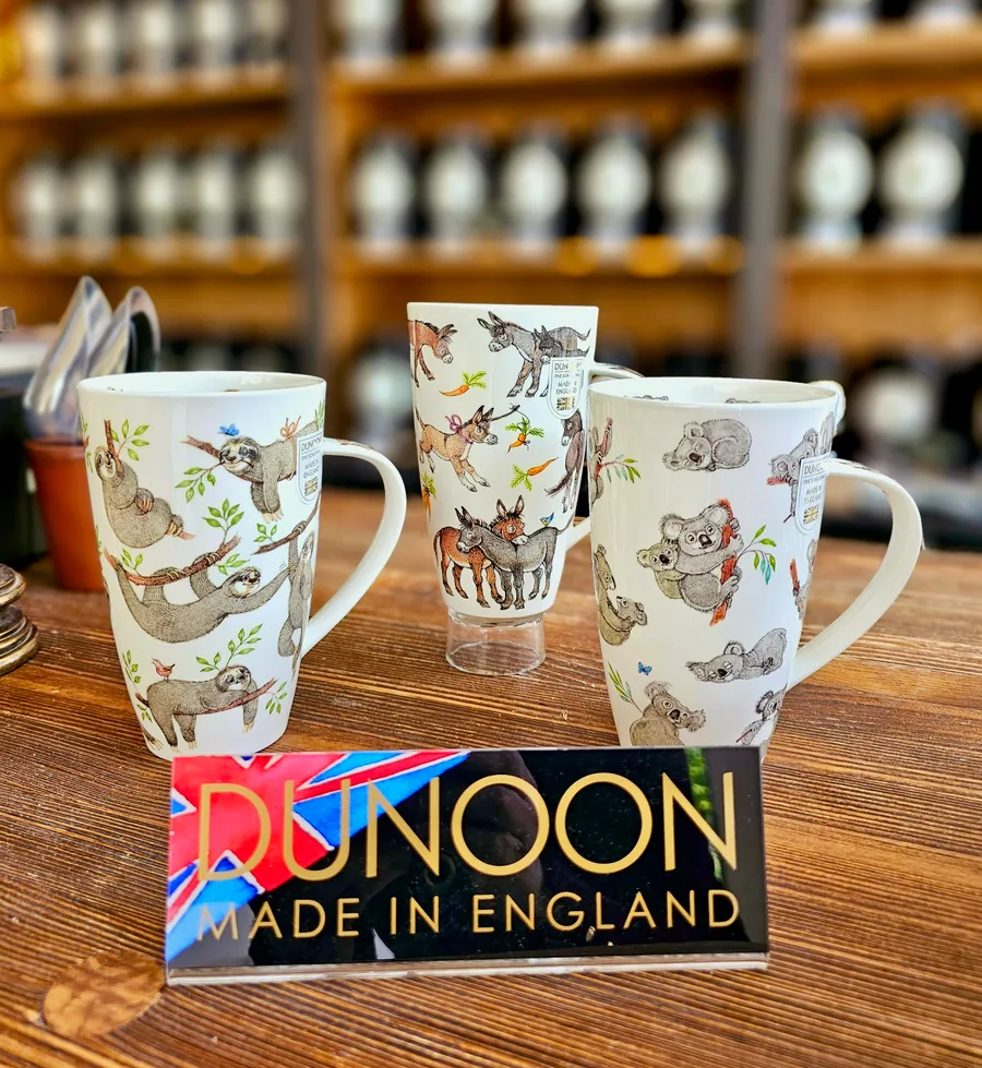 Three Dunoon porcelain cups with sloth, donkey and koala designs on the wooden counter