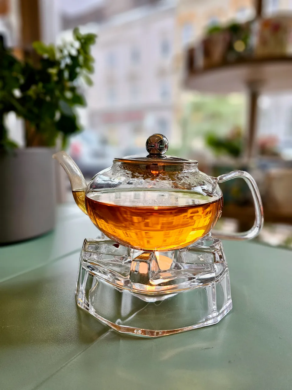 Té dorado brillante en una tetera de cristal sobre un calentador de cristal