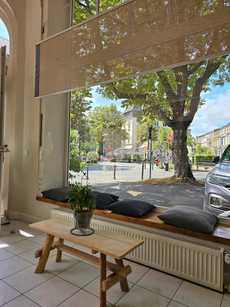 Ruhige Sitzbank am Schaufenster des Lupercia-Salons mit Blick in die sonnendurchflutete Argelanderstraße, Bonn-Südstadt